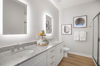 a bathroom with two sinks and a shower and a toilet